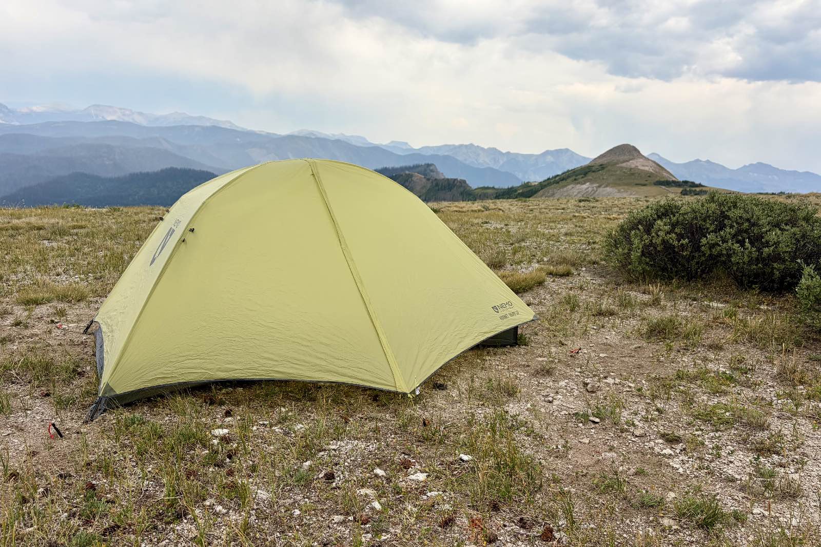 a backpacking tent pitched with a mountain background