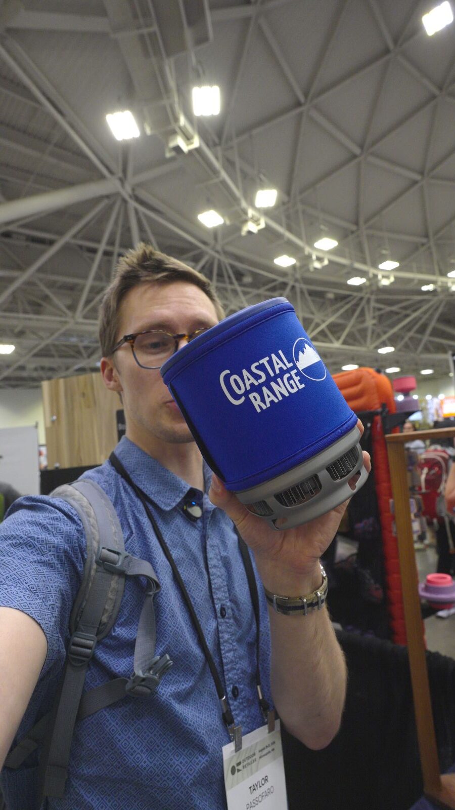 A man holds a blue backpacking stove pot.