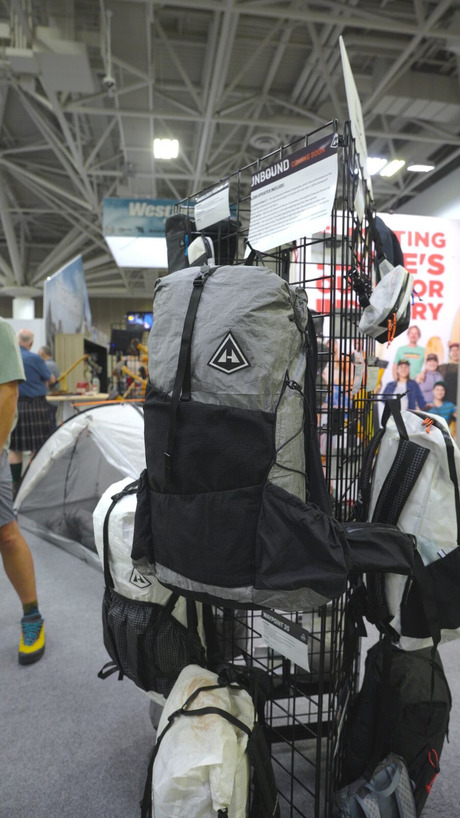 A grey backpack hangs from a trade show display
